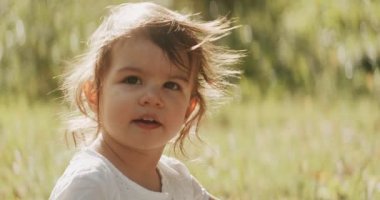 Yaz sonlarında parkta gezen tatlı bir kız. 4K RAW 'da bir sinema kamerasında çekildi. Anamorfik bokeh.