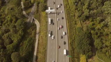 Bulutlu bir günde karayolu trafiğinin havadan çekilmiş görüntüsü. Sinematik 4K görüntüleri.