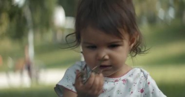 Yazın parkta gezen tatlı bir kız. Gerçek hayat, gizli görüntüler. 4K RAW 'da bir sinema kamerasında çekildi..