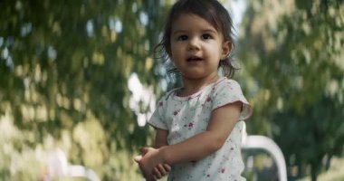 Yazın parkta gezen tatlı bir kız. Gerçek hayat, gizli görüntüler. 4K RAW 'da bir sinema kamerasında çekildi..