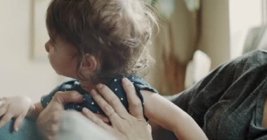 Anne evde kızıyla kanepede oynuyor. Gerçek hayat, gizli görüntüler. 4K RAW 'da bir sinema kamerasında çekildi..