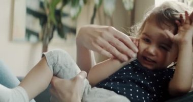 Anne evde kızıyla kanepede oynuyor. Gerçek hayat, gizli görüntüler. 4K RAW 'da bir sinema kamerasında çekildi..