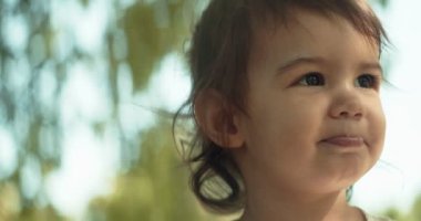 Yazın parkta gezen tatlı bir kız. Gerçek hayat, gizli 4K görüntüleri. Anamorfik bokeh.