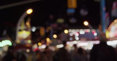 Geceleri panayır alanı. Odaklanamayan görüntü. 4K RAW 'da bir sinema kamerasında çekildi..