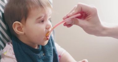 Annesi tarafından beslenen küçük bir kız bebek. 4K samimi, gerçek hayat ve sahnelenmemiş görüntüler.