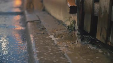 Fırtına sırasında bir ara sokağa süzülen yağmurun sinematik görüntüsü. 4K görüntü.