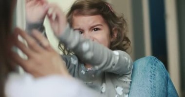Küçük kız annesinin kucağında öfke nöbeti geçiriyor. Bir sinema kamerasında çekilmiş..