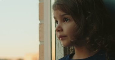 Küçük kız pencereden bir şeyi işaret ediyor. Sinema kamerasında çekilmiş..