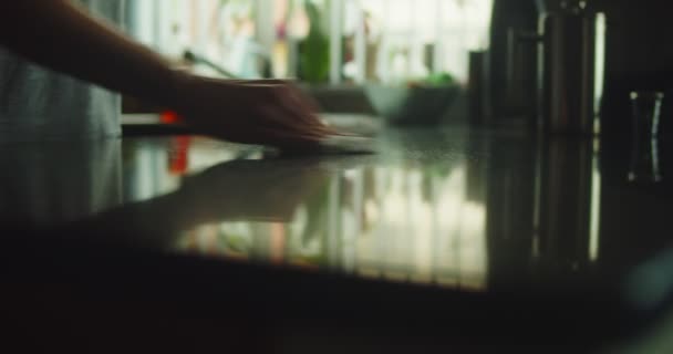 キッチンカウンターを拭く女性の手のクローズアップスライダーショット 映画館のカメラで4Kで撮影 — ストック動画