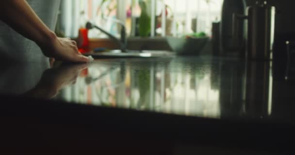 キッチンカウンターを拭く女性の手のクローズアップスライダーショット 映画館のカメラで4Kで撮影 スローモ — ストック動画