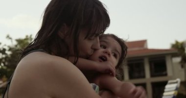 Anne ve bebek havuz başında eğleniyorlar. 4K 'da bir sinema kamerasında çekildi..