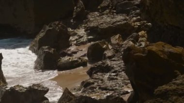 Dalgalar Porto Riko 'daki bir plajda kayalara çarpıyor. Sinematik 4K çekim yapıyor. Yavaş çekim.
