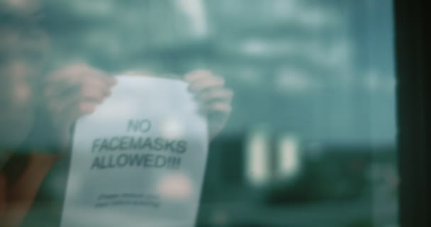 Kadın Kapıya Maske Karşıtı Bir Tabela Asıyor Bir Sinema Kamerasında — Stok video