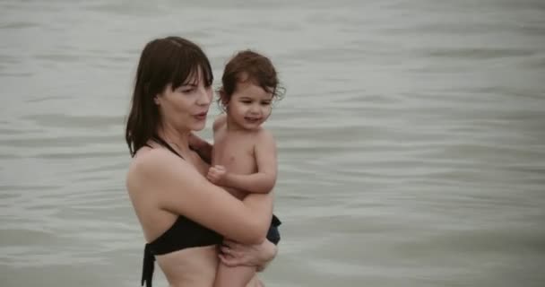 엄마와 아기는 해변에서 즐겁게 지낸다 카메라로 입니다 슬라이드 — 비디오