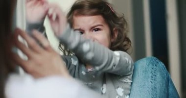 Küçük kız annesinin kucağında öfke nöbeti geçiriyor. Bir sinema kamerasında çekilmiş..