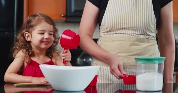 かわいい幼児の女の子は彼女のお母さんがクッキーを作るのを助ける 映画館のカメラで撮影 — ストック動画