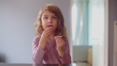 Kurabiye yiyen küçük tatlı bir kızın portresi. 4K 'da sinema kamerasında çekildi..