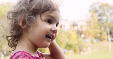 Sonbaharda parkın keyfini çıkaran tatlı bir bebek. Gerçek hayattaki görüntüler. 4K 'da çekilmiş..