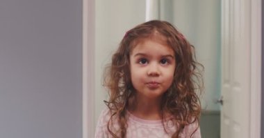 Küçük tatlı bir kızın komik suratlar yaptığı portre. 4K görüntü.