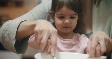 Küçük tatlı kız anneme kurabiye yapmada yardım ediyor. 4K RAW 'da bir sinema kamerasında çekildi..