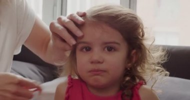 Anne küçük kızların saçlarını tarıyor. Bir sinema kamerasında çekilmiş..