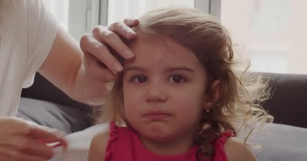 母親は幼い女の子の髪をブラッシング 映画館のカメラで撮影 — ストック動画