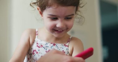Anne ve bebek cep telefonuyla etkileşim halindeler. 4K 'da bir sinema kamerasında çekildi..