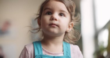 Evdeki kanepede yeni yürümeye başlayan bir kızın portresi. 4K RAW 'da bir sinema kamerasında çekildi..