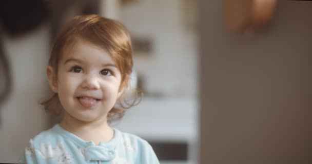 普通の日に自宅でかわいい面白い小さな幼児の女の子の肖像画 シネマカメラで4K Rawで撮影 — ストック動画