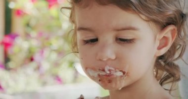 Dondurma yiyen ve ortalığı kirleten tatlı bir kız. Bir sinema kamerasında çekilmiş..