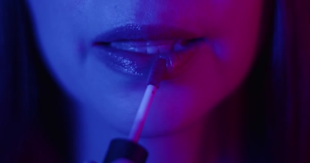 Κοντινό Πορτρέτο Της Γυναίκας Που Εφαρμόζει Lip Gloss Στο Φως — Αρχείο Βίντεο