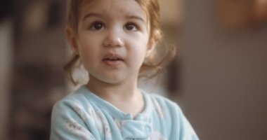 Normal bir günde evde sevimli, komik, küçük bir kızın portresi. 4K RAW 'da bir sinema kamerasında çekildi..