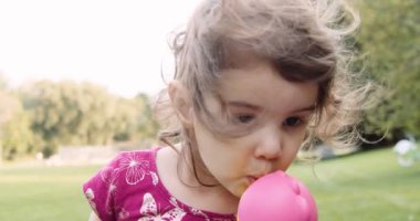 Sonbaharda parkın keyfini çıkaran tatlı bir bebek. Gerçek hayattaki görüntüler. 4K 'da çekilmiş..