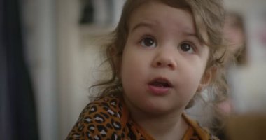 Normal bir günde evde sevimli, komik, küçük bir kızın portresi. 4K RAW 'da bir sinema kamerasında çekildi..