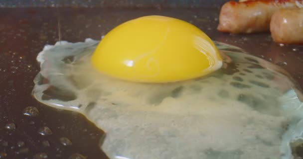Spräcka Ett Ägg Griddle Med Korv Matlagning Bakgrunden Makroskott — Stockvideo