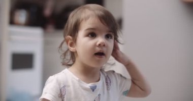 Normal bir günde evde sevimli, komik, küçük bir kızın portresi. 4K RAW 'da bir sinema kamerasında çekildi..
