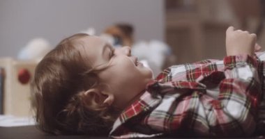 Normal bir günde evde sevimli, komik, küçük bir kızın portresi. 4K RAW 'da bir sinema kamerasında çekildi..