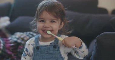 Dişlerini fırçalayan komik küçük kız. 4K RAW 'da bir sinema kamerasında çekildi..