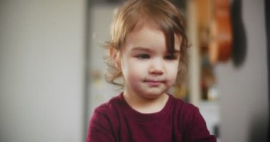 Normal bir günde evde sevimli, komik, küçük bir kızın portresi. 4K RAW 'da bir sinema kamerasında çekildi..