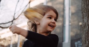 Sonbaharda parkın keyfini çıkaran tatlı bir bebek. Gerçek hayattaki görüntüler. 4K 'da çekilmiş..