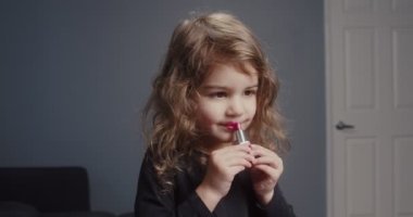 İlk kez ruj deneyen tatlı bir kız. 4K görüntü.