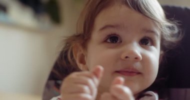 Mutlu küçük kız ellerini çırpıyor. 4K RAW 'da bir sinema kamerasında çekildi..