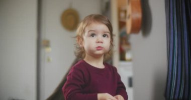 Normal bir günde evde sevimli, komik, küçük bir kızın portresi. 4K RAW 'da bir sinema kamerasında çekildi..