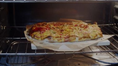 Ev yapımı pizza kabuğuyla pizza taşından alınıyor. 4K sinematik çekim.