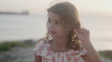 Beş yaşındaki bir kızın tropik yaz tatili boyunca aptalca gülümsemesi çocukluğun kaygısız ruhunu yansıtıyor.