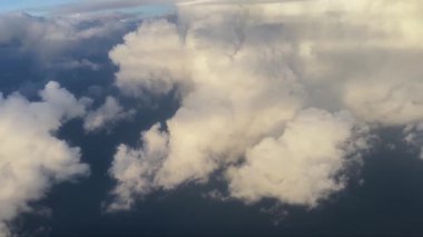 Bir uçak penceresinden nefes kesici bulutlu manzaralar, gökyüzünün muazzam güzelliğini gösteriyor. Doğayı, ihtişamı ve sükuneti vurgulayan projeler için ideal.