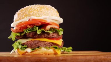 Bir gurme hamburgerin ağız sulandıran kahraman fotoğrafı, 4K 'da özel bir stüdyo ışıklandırmasıyla çekildi..