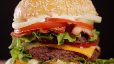 Bir gurme hamburgerin ağız sulandıran kahraman fotoğrafı, 4K 'da özel bir stüdyo ışıklandırmasıyla çekildi..