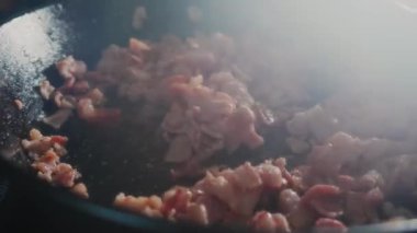 4K sinematik pastırma sahnesi dökme demir tavada cızırdıyor. Gurme yemek videoları ve yemek programları için detaylı yakın çekim mükemmel.