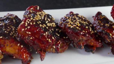 Ağzını sulandıran Kore barbekü soslu tavuk butları gochujang kaplı, haşhaş tohumlarıyla süslenmiş..